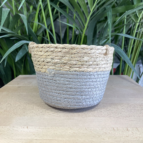 Panier décoratif en fibres naturelles avec un style tressé, en vue générale sur la base gris