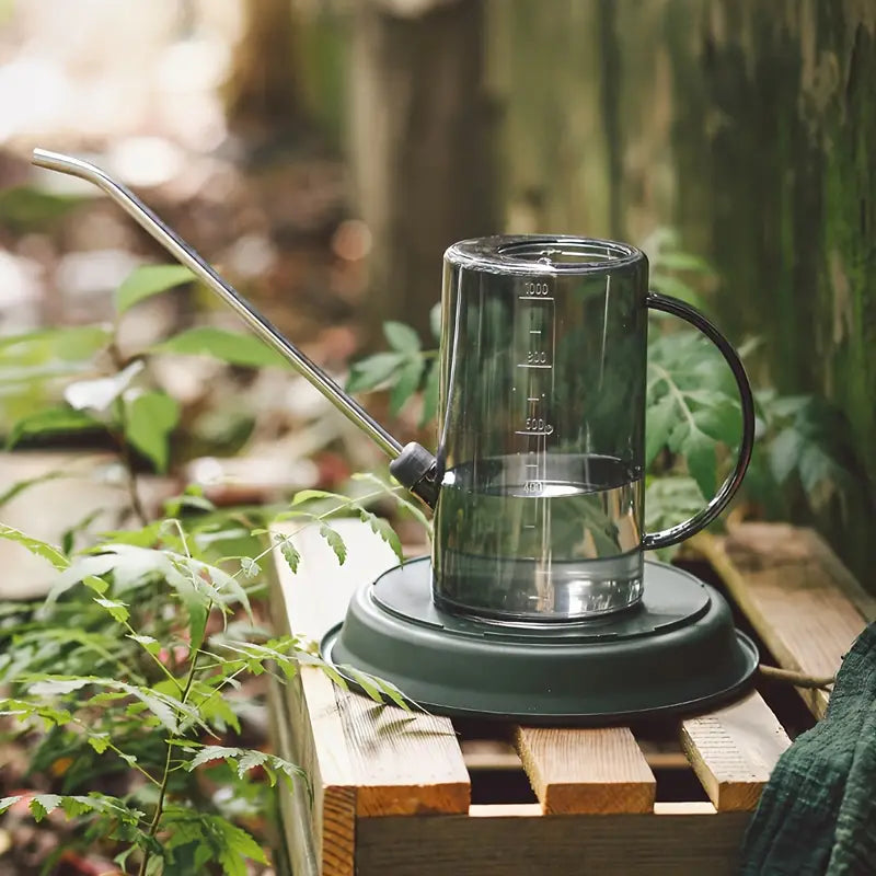 Arrosoir au design élégant avec un long bec fin, utilisé pour arroser des plantes dans un environnement extérieur