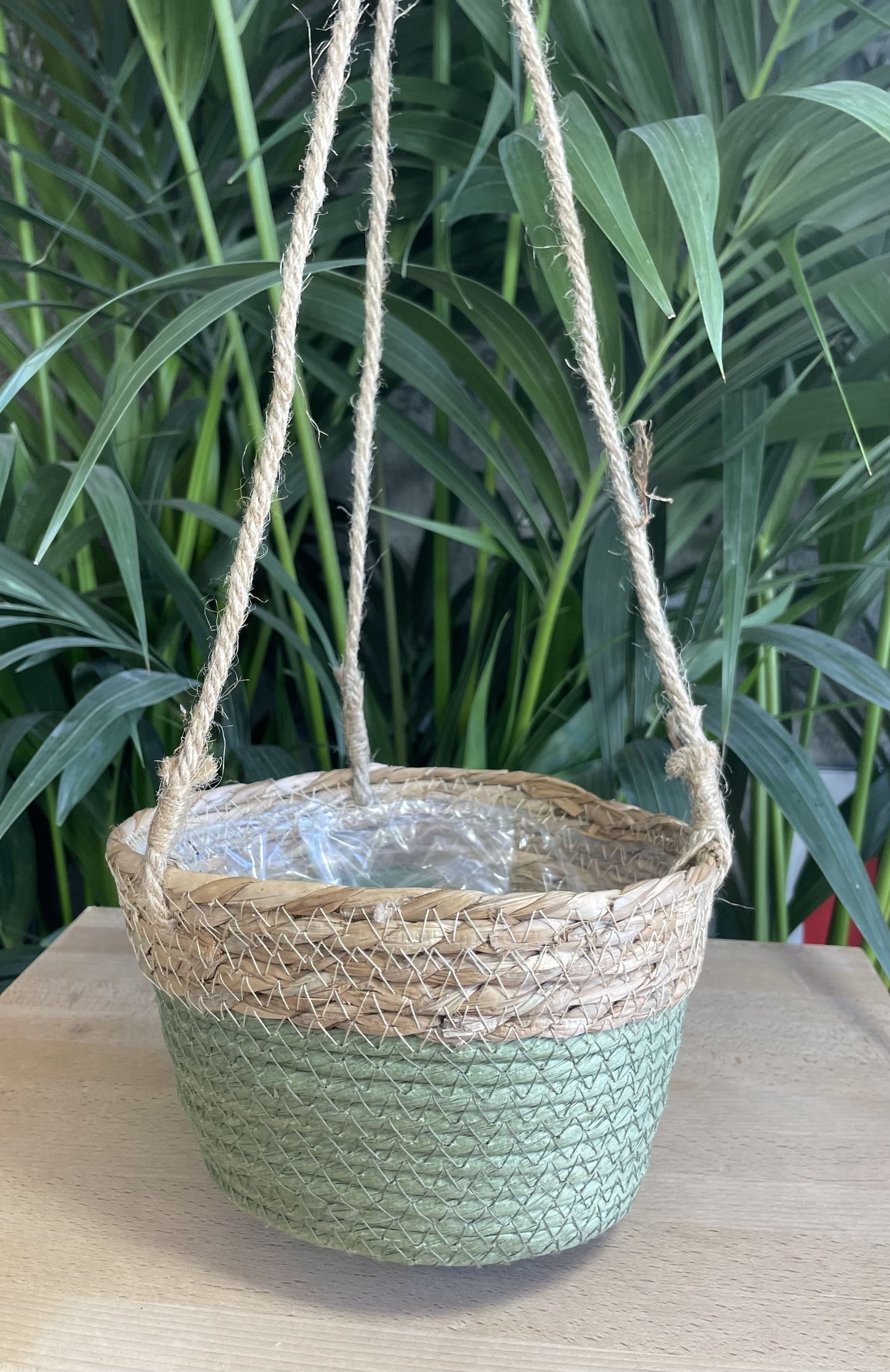 Panier suspendu en fibres naturelles avec une base verte, parfait pour suspendre des plantes en intérieur ou extérieur