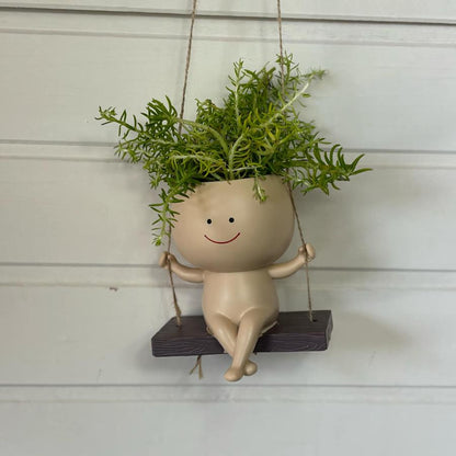 petit pot de plante avec des cheveux formés par des plantes